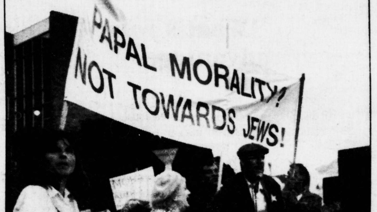 This photo appeared on the front page of our Sept. 25, 1987 issue with this caption:
"Daniel Lev plays guitar outside St. Mary’s Cathedral last week at [a] demonstration
that was one of many Jewish community protests and events aimed at the
pope's visit to San Francisco. The demonstration merged protests organized by
the Northern California Holocaust Center and by Tikkun Magazine."